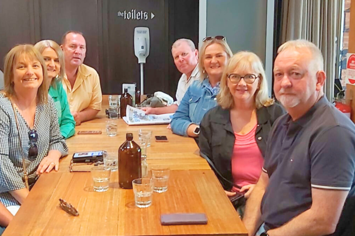 a group of people sitting at a table with wine glasses