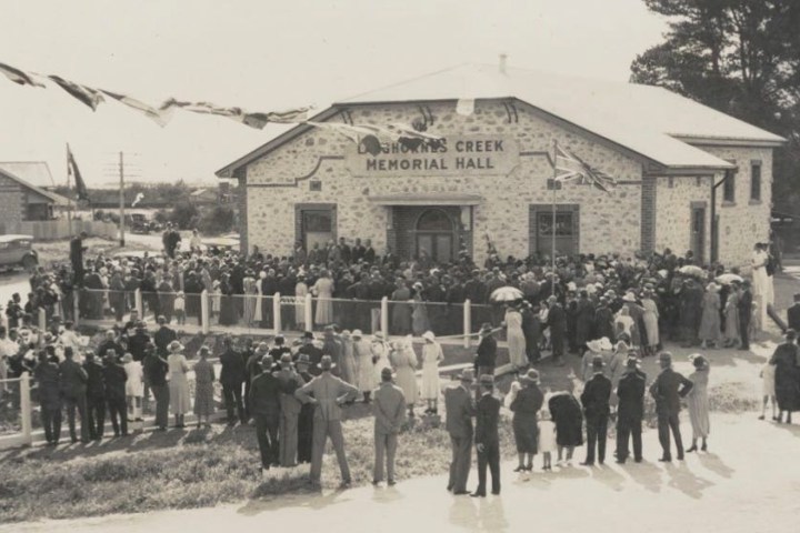 a vintage photo of a group of people standing in front of a building