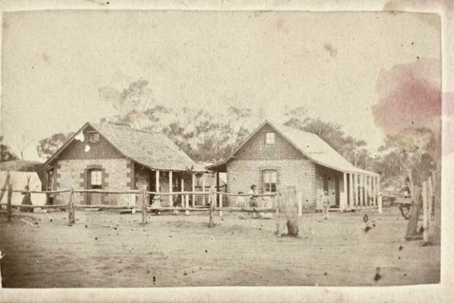 an old barn in front of a house