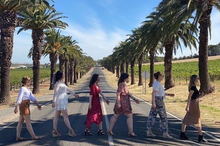 a group of people standing next to a palm tree