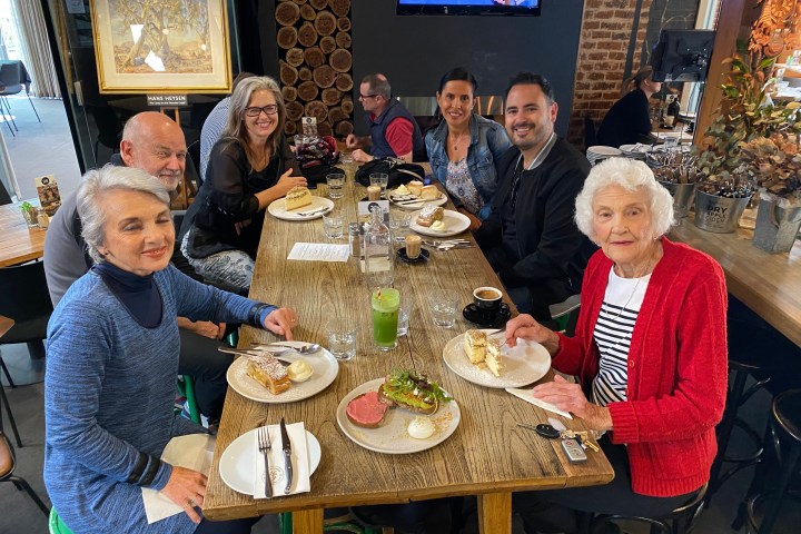 a group of people sitting at a table with food