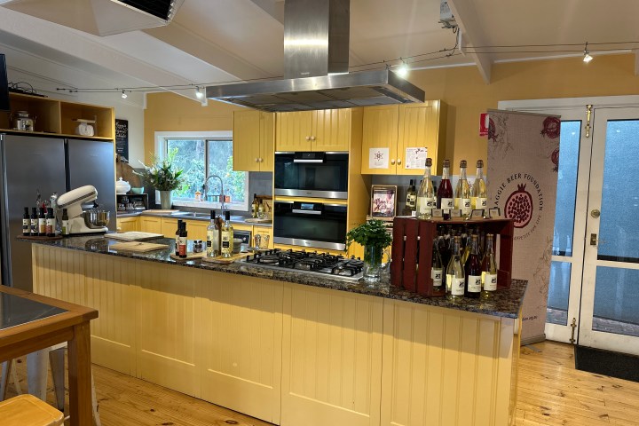 Spacious kitchen with yellow cabinets, kitchen island, appliances, and bottles displayed.