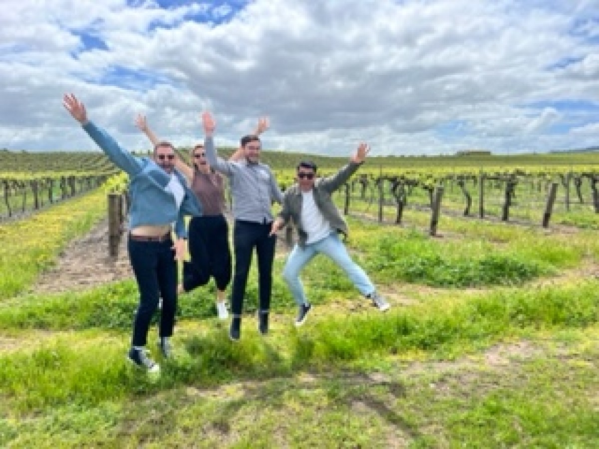 a group of people standing on top of a grass covered field