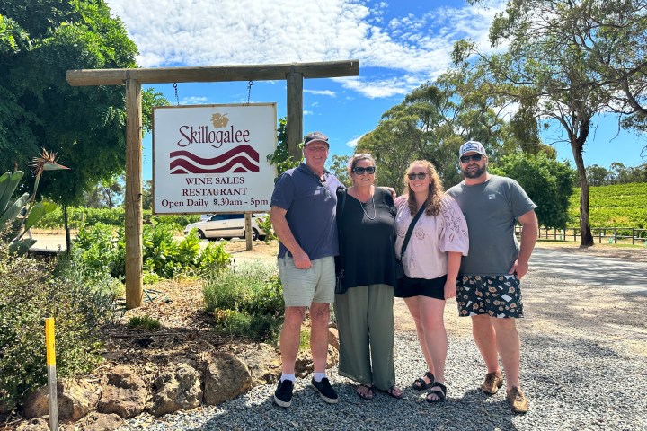 a group of people standing in front of a sign
