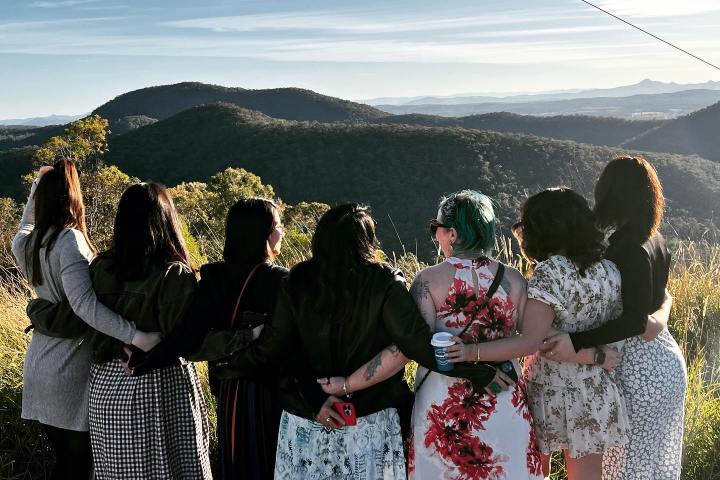 a group of people standing in front of a mountain