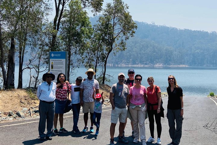 a group of people standing in front of a tree posing for the camera
