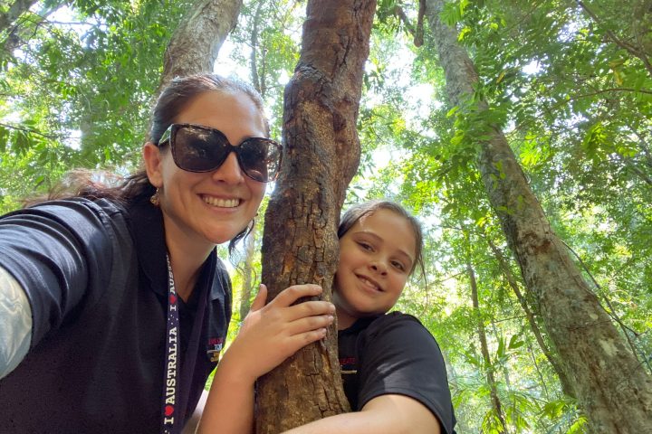 a man and a woman standing next to a tree