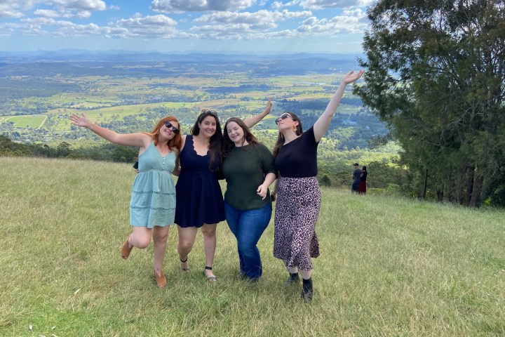 a group of people standing on top of a grass covered field