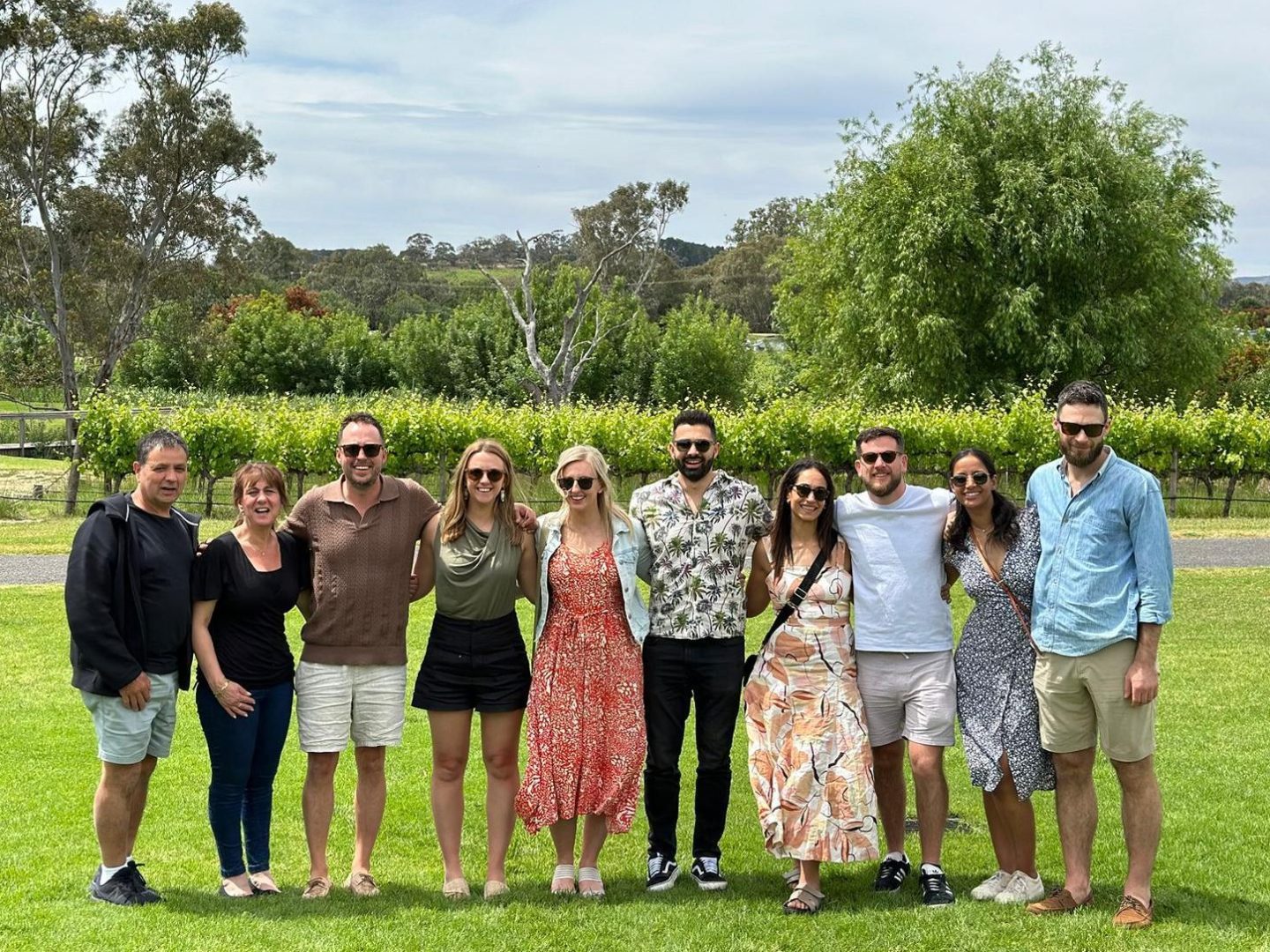 a group of people standing in a grassy area posing for the camera
