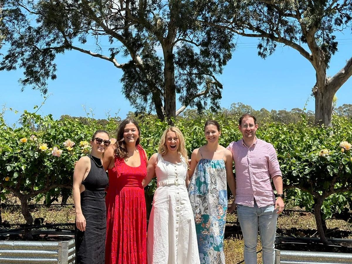 a group of people standing in front of a tree posing for the camera
