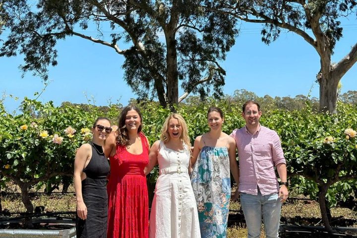 a group of people standing in front of a tree posing for the camera