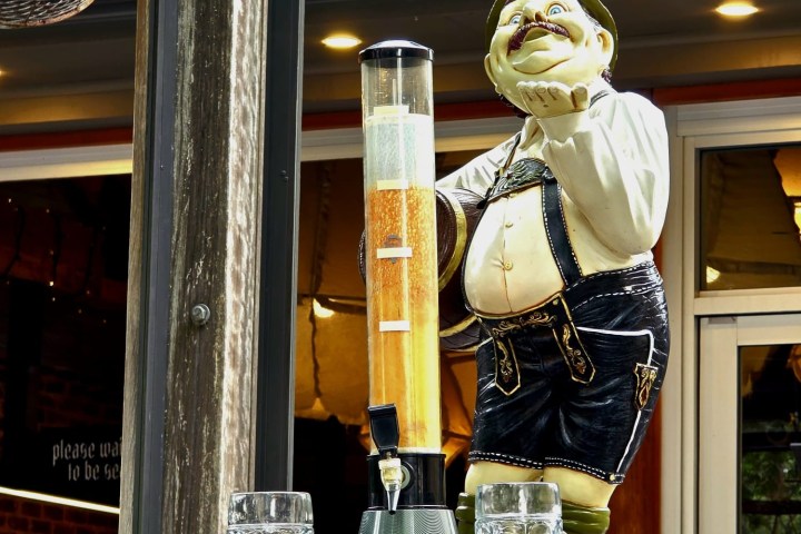 Statue of a man with beer tower, Hahndorf sign above, two empty mugs in front.